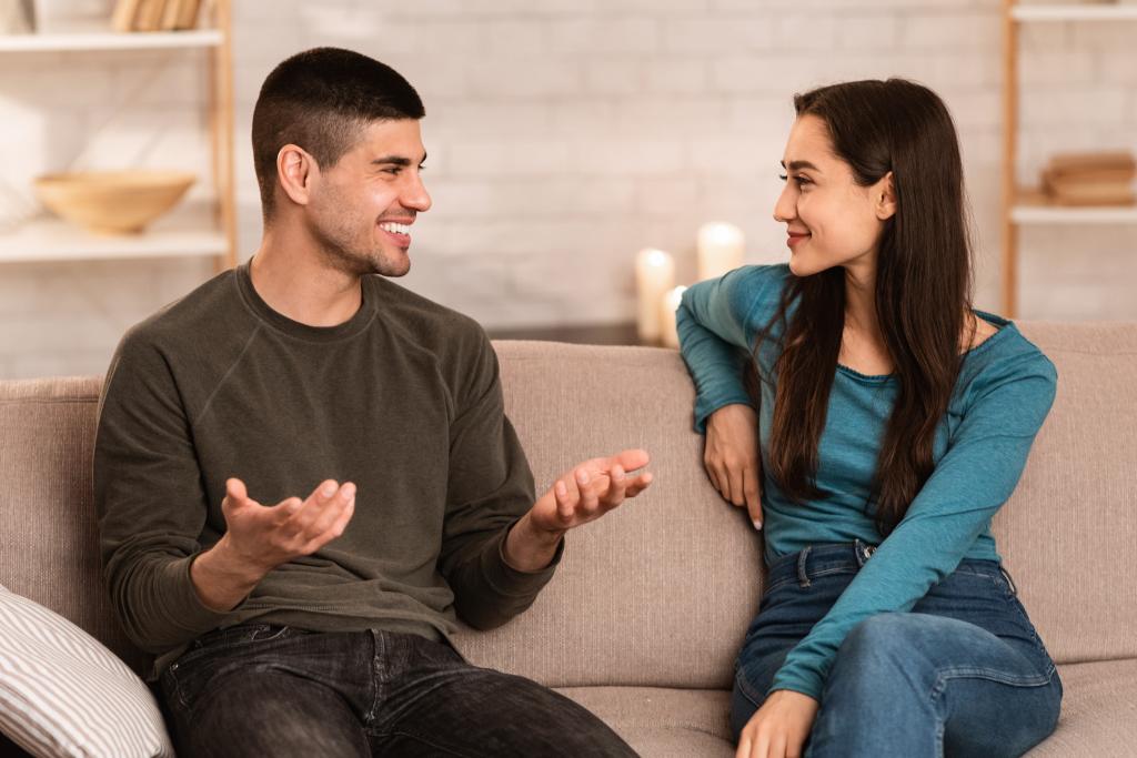 A man and a woman sitting on a couch, having a lively conversation